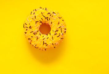 Delicious donut on yellow background with copyspace.
