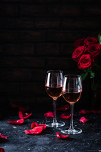 Two Wine Glasses Of Rose Wine On Brick Background, Bouquet Of Red Roses For Romantic Evening For Valentines Day Surprise, Marriage Proposal Passion And Love Celebration, Copy Space 