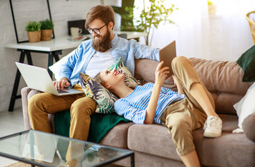 Wall Mural - happy couple relaxing at home with laptop and tablet