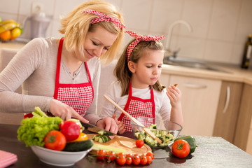 Mother and daughter making salad