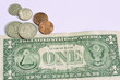 one dollar bill and coins on withe background