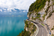 A Curved Road Built Into The Side Of A Mountain Next To Lake Thun, Interlaken, Bernese Oberland, Bern