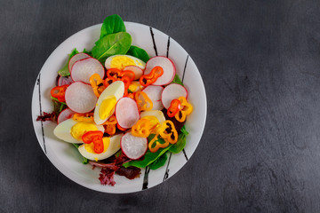 Wall Mural - Green salad with eggs on wood background. Top view.