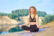 © Kiryl Lis - Attractive redhead curly woman or model practicing yoga outdoors
