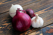 Red White Onion And Garlic On Wooden Background.