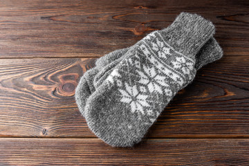 Warm mittens on wooden background.