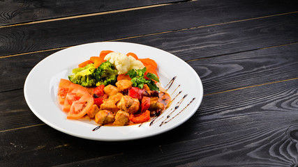 Wall Mural - italian dish of chicken and vegetables on wooden black background