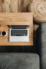 Wall Mural - Top view of laptop, coffee cup and candle on wooden table. Blogger / freelancer home office workspace flatlay. Modern nordic interior design concept.