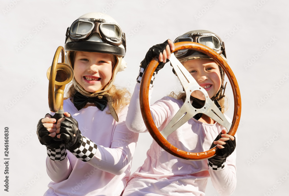 Twin sisters play race car driver sitting in their imaginative race car ...