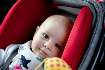 Little baby boy and his older brother, traveling in car seats, going on a holiday