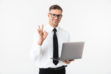 Sticker - Handsome business man isolated over white wall background using laptop computer.