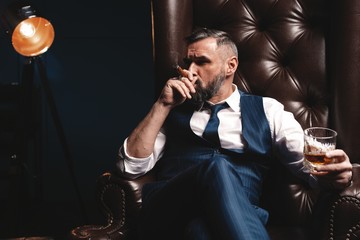 Wall Mural - Attractive man with cigar and a glass whiskey