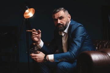 Wall Mural - Attractive man with cigar and a glass whiskey