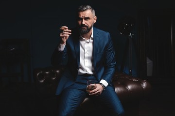 Wall Mural - Attractive man with cigar and a glass whiskey