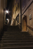Fototapeta Uliczki - Stein Treppe mit Stufen an Haus mit Tür und Fenstern bei Nacht mit Strassenlampe und Licht