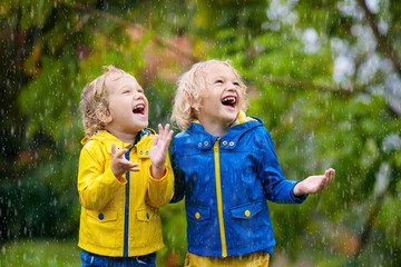 Wall Mural - Kids play in autumn rain. Child on rainy day.