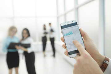 close up. a businessman uses a smartphone to check the financial data