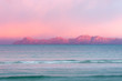 canvas print picture - Rosaroter Himmel über den Bergen am Horizont beim Sonnenuntergang am Meer