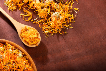 Wall Mural - Dried calendula petals - Calendula officinalis. Wood background