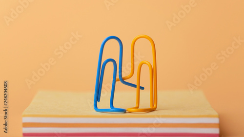 Fotomural loving couple of clips sits on a stack of sheets of paper hugging and holding ha