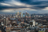 Fototapeta Londyn - Blick über die Skyline von London auf das Finanzzentrum Canary Wharf mit dunklen Wolken