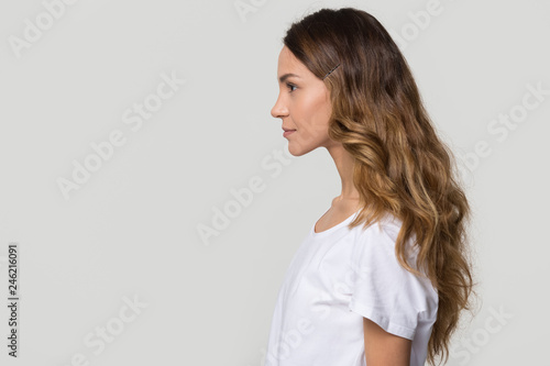 Fotografía Young female millennial woman standing in profile on white grey background with