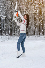 Canvas Print - Woman in a sweater and jeans holds a chainsaw in her hands in the woods. Deforestation, sawing, lumberjack and forestry equipment.