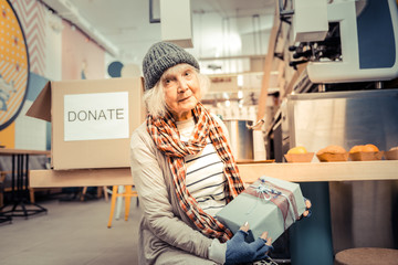 Wall Mural - Nice joyful homeless woman receiving a gift