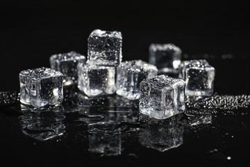 pile of crystal clear ice cubes on black background