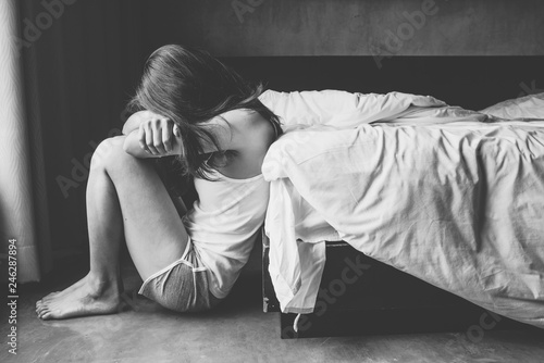Cuadros en Lienzo Depressed woman sitting alone in bedroom.