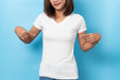 © suriya - Portrait of asian woman in a blank white T-shirt on blue background Mock-up
