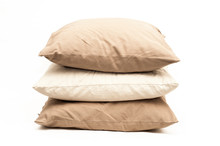 Three beige pillows on a white background. Burlap pillow cases