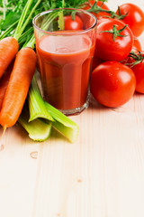 Glass of different vegetable juices with carrots, tomatoes and c