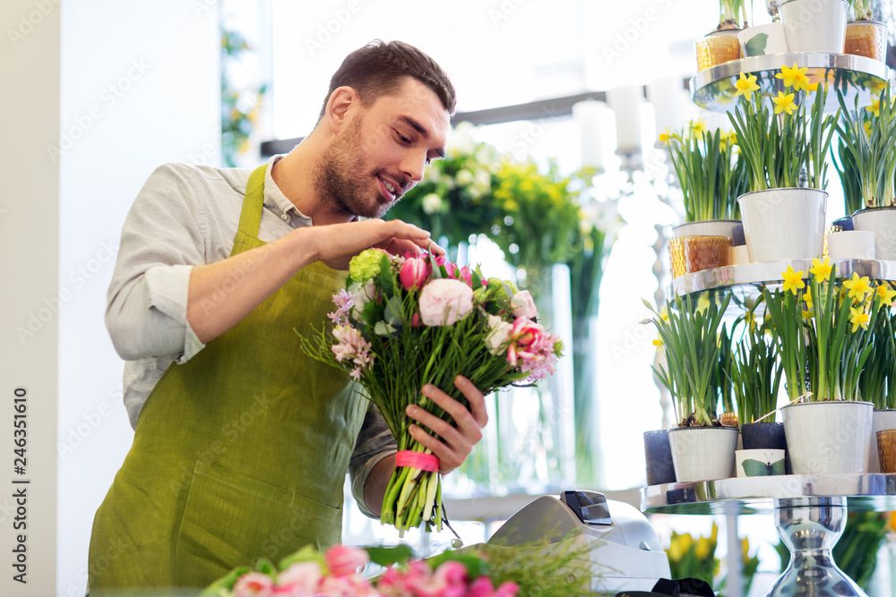 people, business, sale and floristry concept - happy smiling florist man making bunch at flower shop - obrazy, fototapety, plakaty 
