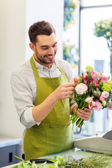 people, business, sale and floristry concept - happy smiling florist man making bunch at flower shop