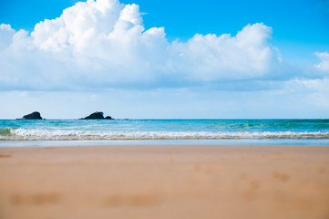 Light waves. Ocean and sand. Summer Islands, blue sky and clouds.