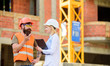 © be free - Construction industry concept. Discuss progress project. Woman engineer and bearded brutal builder discuss construction progress. Construction project management. Building industrial project