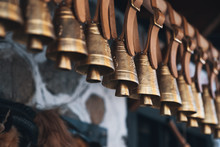 Brass Bells Hanging Outside On Leather Straps