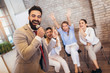 © Mediteraneo - Business people making team training exercise during team building seminar singing karaoke.