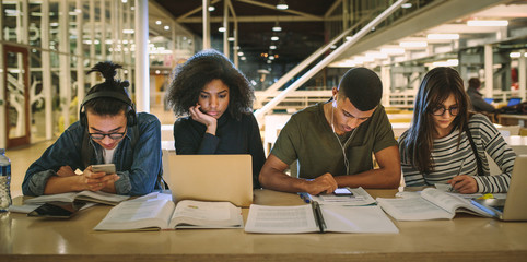 multi-ethnic students sitting at college library