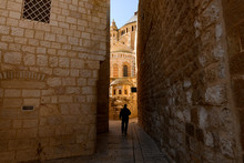 Silhouette Of A Tourist Walking In An Alleyway In The Old City Of Jerusalem, Israel. The Old City Is A 0.9 Square Kilometres Walled Area Within The Modern City Of Jerusalem.