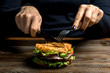 © Алексей Еремеев - Healthy lifestyle, proper nutrition. Female hands cut a useful rice burger with vegetables, herbs and cutlet on a wooden board