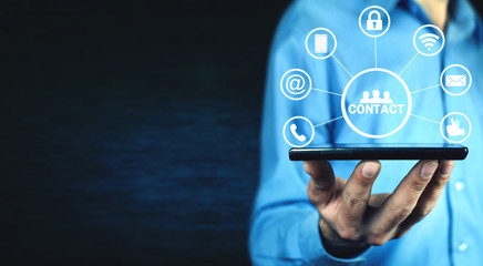 Wall Mural - man holding phone with contact icons.