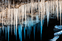 Many Icicles Hanging From The Ceiling Of The Cave.