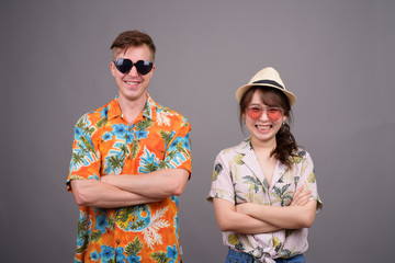 Multi ethnic tourist couple wearing sunglasses and Hawaiian shirt