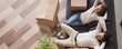 © fizkes - Horizontal above concept photo married couple at moving day rest relax on couch cardboard boxes on floor feels satisfied breathing fresh air, banner for website header design with copy space for text