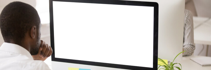 Rear view from the shoulder black worker use pc at workplace look at white close up screen mock up read business email do office work concept, banner for website header design with copy space for text