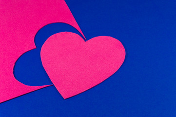 Hearts cut out of bright color foam sheets on blue