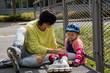 © HappyHaus - pretty woman sitting with a little girl resting after active roller skating
