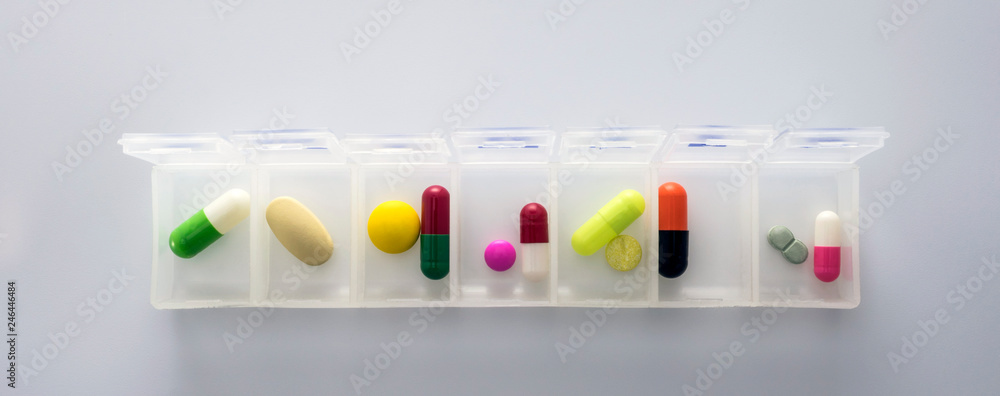 weekly pillbox with medication, conceptual image, horizontal composition - obrazy, fototapety, plakaty 